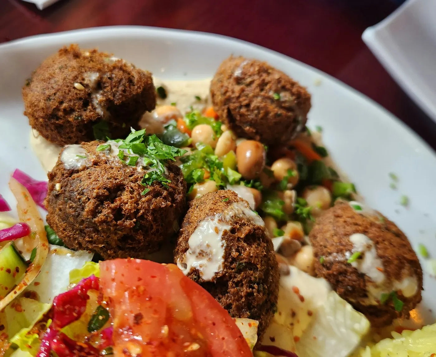 Falafel with hummus, chickpea salad and fresh vegetables on a plate