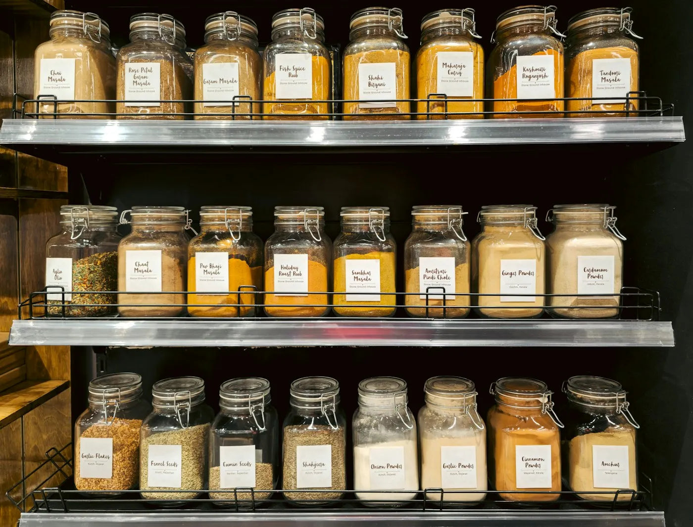 Glass jars of ground spices on a shop shelf