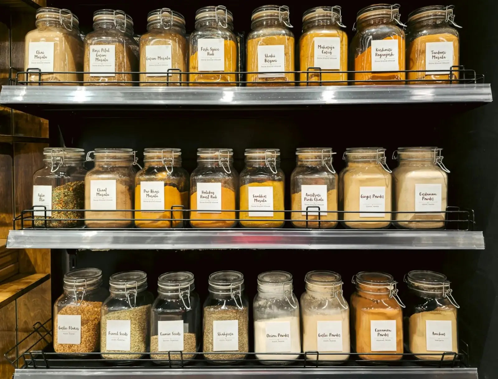 Glass jars of ground spices and spice blends on a shop shelf